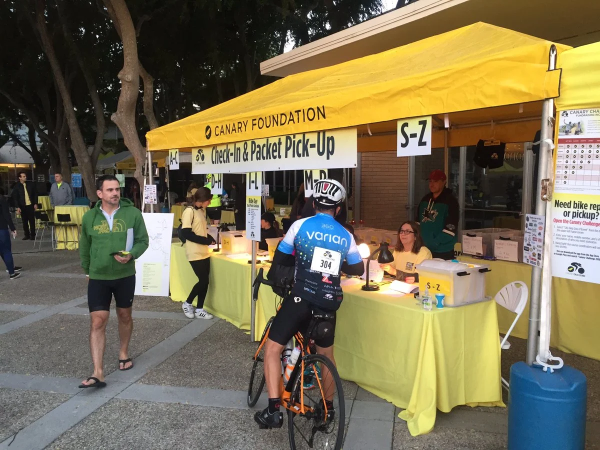 Historic photo of Canary Foundation booth with volunteers supporting participants during past challenge events